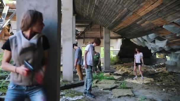 Ein Zombie-Angriff auf die oberste Etage eines verlassenen Gebäudes. überlebte Frau mit Waffe, die sich hinter einer Säule vor Zombies versteckt — Stockvideo