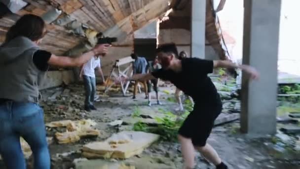 放棄された建物のゾンビ攻撃。ゾンビを避ける銃で走っている生き残った女性 — ストック動画