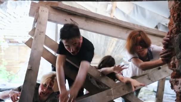 Zombies presos na cerca e puxando as mãos para obter uma pessoa — Vídeo de Stock
