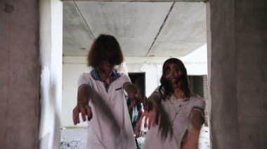Terk edilmiş binadaki karanlık koridorda yürüyen zombiler.