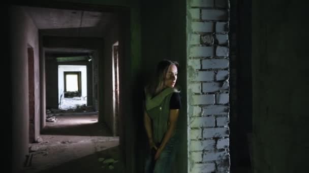 僵尸启示。幸存的妇女拿着枪在废弃的大楼里行走。注意僵尸，躲在墙后 — 图库视频影像