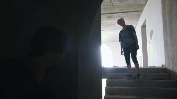 En zombie går på trappan och en man överlevande som siktar med en pistol i dem — Stockvideo