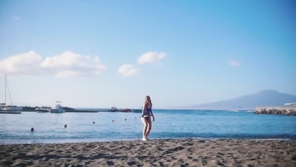 Egy fiatal férfi játszik Frisbee a strandon a női barátja. Elkapta a lemezt, és alá a homokba — Stock videók