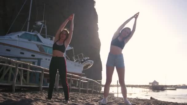 Hacer aeróbic - mujeres jóvenes realizando ejercicios en la playa — Vídeos de Stock