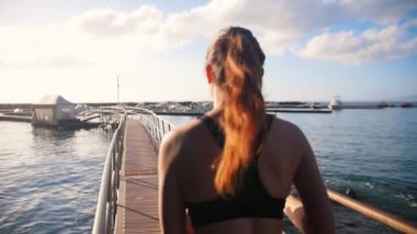 Köprüde deniz limanına doğru koşan iki genç kadın