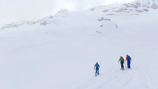 Station de ski. Trois personnes marchant vers le haut par le ski dans une montagne — Photo