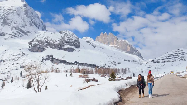 Two young women tourist traveling on the road in Dolomites with big backpack and guitar — Stock Photo, Image