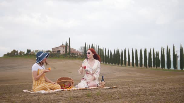 Dwie kobiety posiadające piknik i jedzenie owoców-Toskania, droga cyprysów — Wideo stockowe
