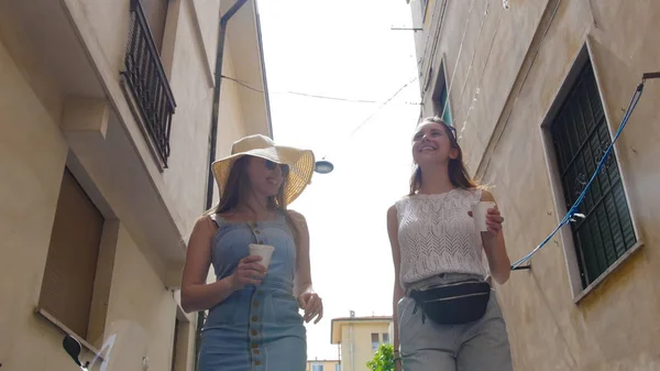 Dos mujeres atractivas caminando en los callejones estrechos y comunicarse —  Fotos de Stock