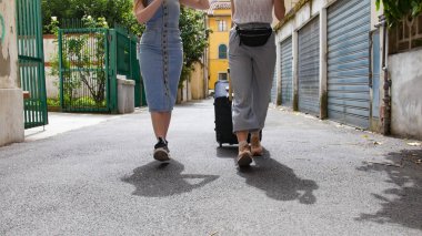 Dar sokaklarda yürüyen iki çekici kadın