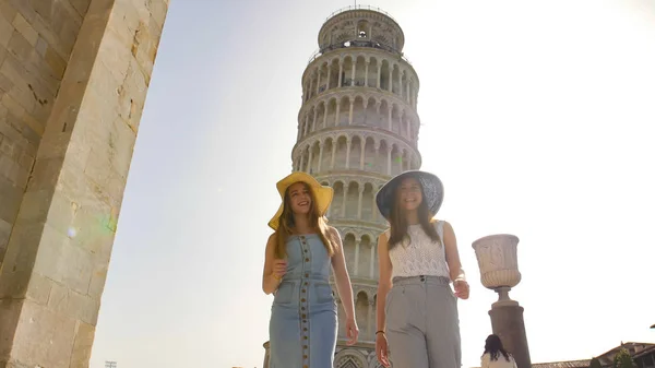 사탑을 배경으로 서 있는 두 명의 젊은 미소 짓는 여성 — 스톡 사진