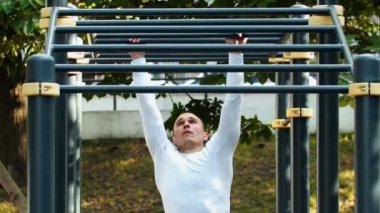 Adam vücut geliştirmeci barda ellerini hareket ettirir