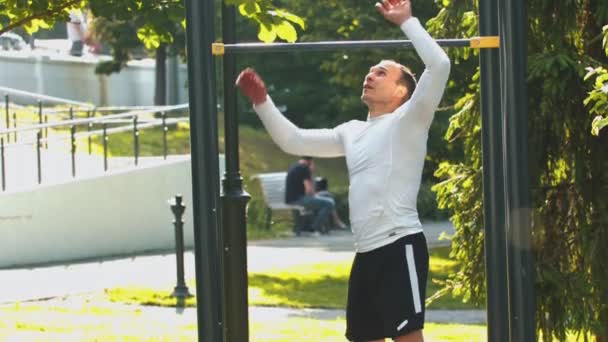 Man bodybuilder komen naar de horizontale balken op het Park — Stockvideo