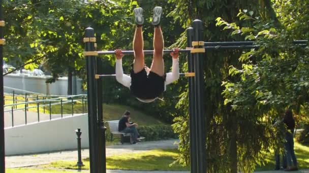 Hombre culturista haciendo ejercicios de entrenamiento en las barras horizontales — Vídeos de Stock