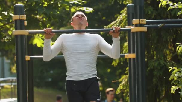 Uomo bodybuilder esegue pull-up sulla barra — Video Stock