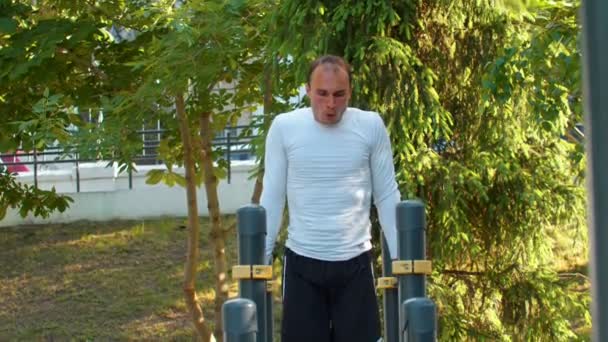 O homem atlético realiza exercícios de treino impressionantes na barra horizontal — Vídeo de Stock