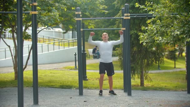 Athletic ember testépítő végez pull-up a vízszintes rúd — Stock videók