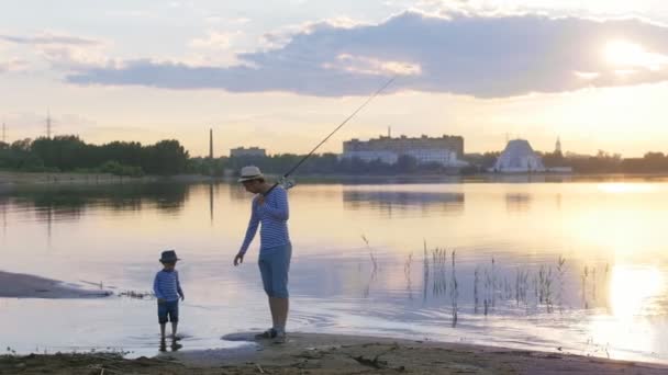Un padre y su hijo en ropa de pareja caminando por la playa tomados de la mano — Vídeos de Stock