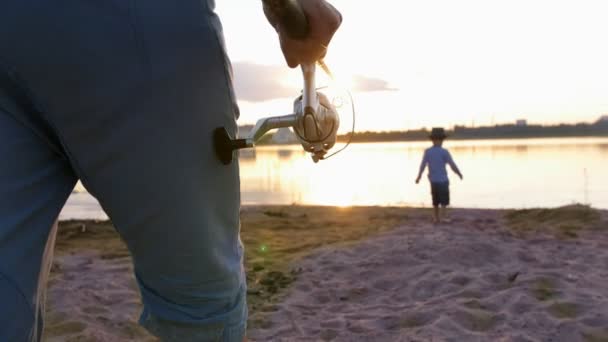 Человек собирается на рыбалку - прогулка по побережью с удочкой — стоковое видео