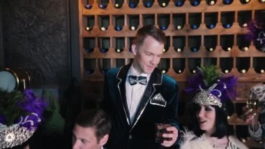 Tema partisi - Masanın arkasında oturan parlak giysiler içinde insanlar - merkezinde bir adam kadar içki bir bardak yükseltir