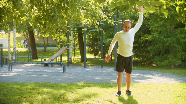 En atletisk man värmer upp med grundläggande övningar — Stockfoto