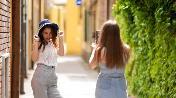 Dos mujeres jóvenes caminando por los callejones - Una de ellas toma una foto para la otra —  Fotos de Stock
