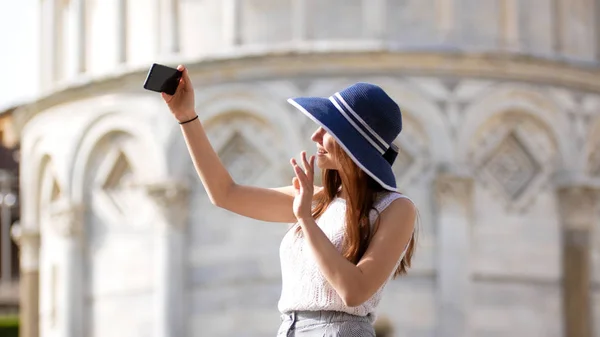Νεαρή ελκυστική γυναίκα στέκεται κάτω Πίζα πύργος πάρει μια selfie και χαιρετούν με το χέρι της — Φωτογραφία Αρχείου