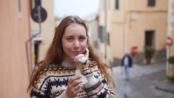 Joven mujer sonriente atractiva comer helado en la calle de la ciudad histórica —  Fotos de Stock