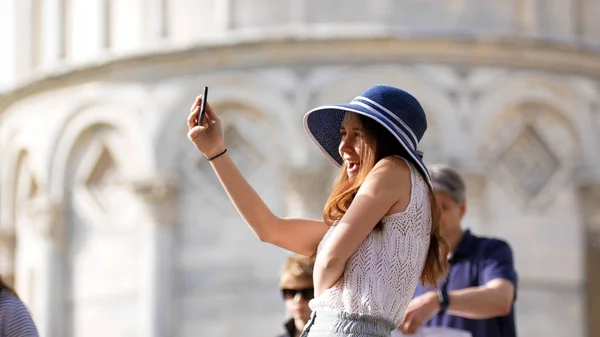 Jovem mulher atraente ficar sob a torre Pisa Posando e tirar uma selfie — Fotografia de Stock