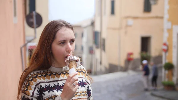 Joven mujer atractiva comer helado en la estrecha calle de la ciudad histórica —  Fotos de Stock