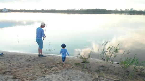 Bir baba ve oğlu birlikte balıkçılık - gün ışığında sahilde ayakta — Stok video