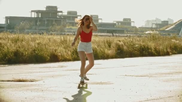 Молода приваблива жінка катається на скейті на відкритому повітрі — стокове відео