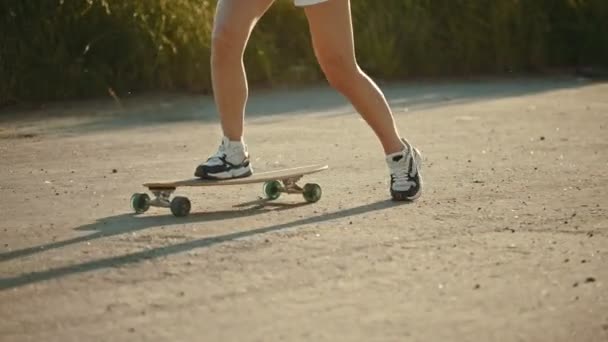 Jovem mulher com pernas agradáveis andar de skate — Vídeo de Stock