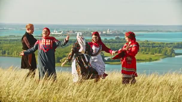 Menschen in traditioneller russischer Kleidung tanzen auf dem Feld zur Musik der Balalaika — Stockvideo