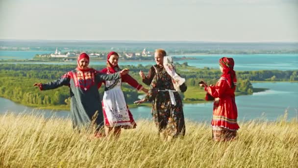 Pessoas com roupas tradicionais russas dançando no campo pela música — Vídeo de Stock