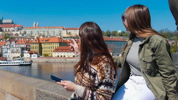 Dos mujeres jóvenes paradas en el puente y mirando a la derecha. Checa, Praga —  Fotos de Stock