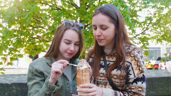 Дві молоді жінки, що ходять по вулицях чеської, Праги і їдять морозиво — стокове фото