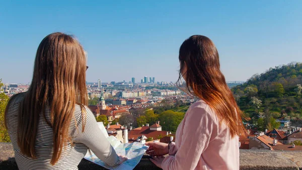 Két fiatal nő állt a megfigyelő fedélzeten, és navigálni a térképen. Csehország, Prága — Stock Fotó