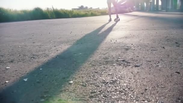 Junge Frau in kleinen weißen Shorts, die draußen Skateboard fährt - grelles Sonnenlicht — Stockvideo