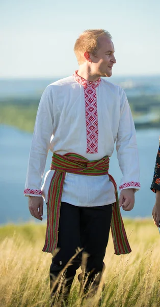 Человек в традиционной русской одежде, стоящий на поле — стоковое фото