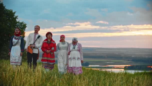 Lidé v tradičních lidových šatech, kteří chodí po hřišti a zpívají píseň — Stock video