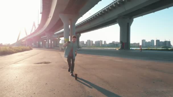 Joven hombre con estilo bailando bajo el puente — Vídeo de stock