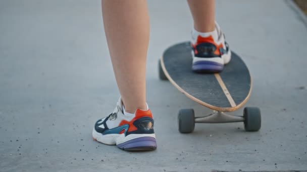 スケートボードに足を踏み入れた若い女性 — ストック動画