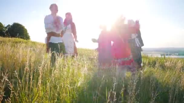 Az emberek a hagyományos orosz ruhát sétálni egy kört, és a szórakozás-ragyogó napfény — Stock videók