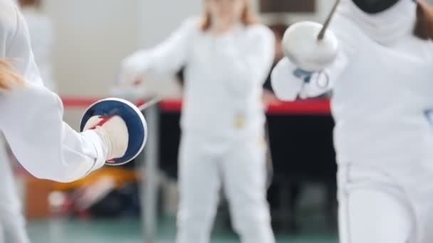 Two teenage girls doing fencing in the gym — Stock Video