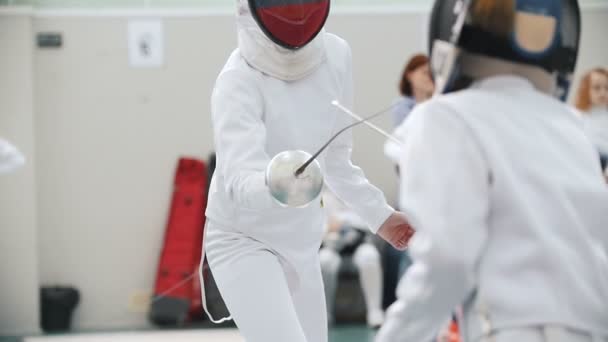 Deux adolescentes font un combat d'escrime avec une épée au gymnase — Video