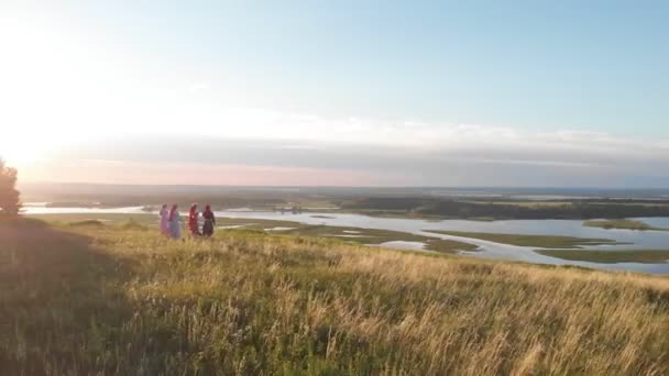 Människor i traditionella ryska kläder dansa och ha kul på det gröna fältet — Stockvideo