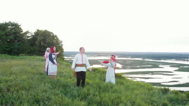 Mann in traditioneller russischer Kleidung singt und um ihn herum singen Frauen — Stockvideo