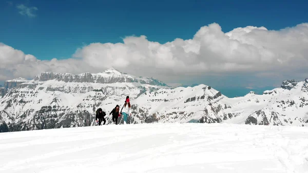 Dolomites'te karda büyük sırt çantalarıyla yukarı doğru yürüyen insanlar — Stok fotoğraf