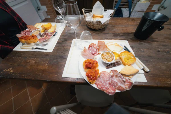 Unfolded table with delicacies - At the table sits a woman